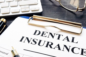 Dental insurance form with pen on blue clipboard
